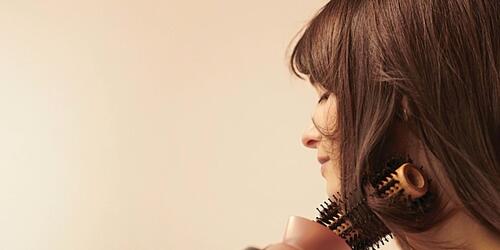 photo of woman blow drying her hair with a panasonic product
